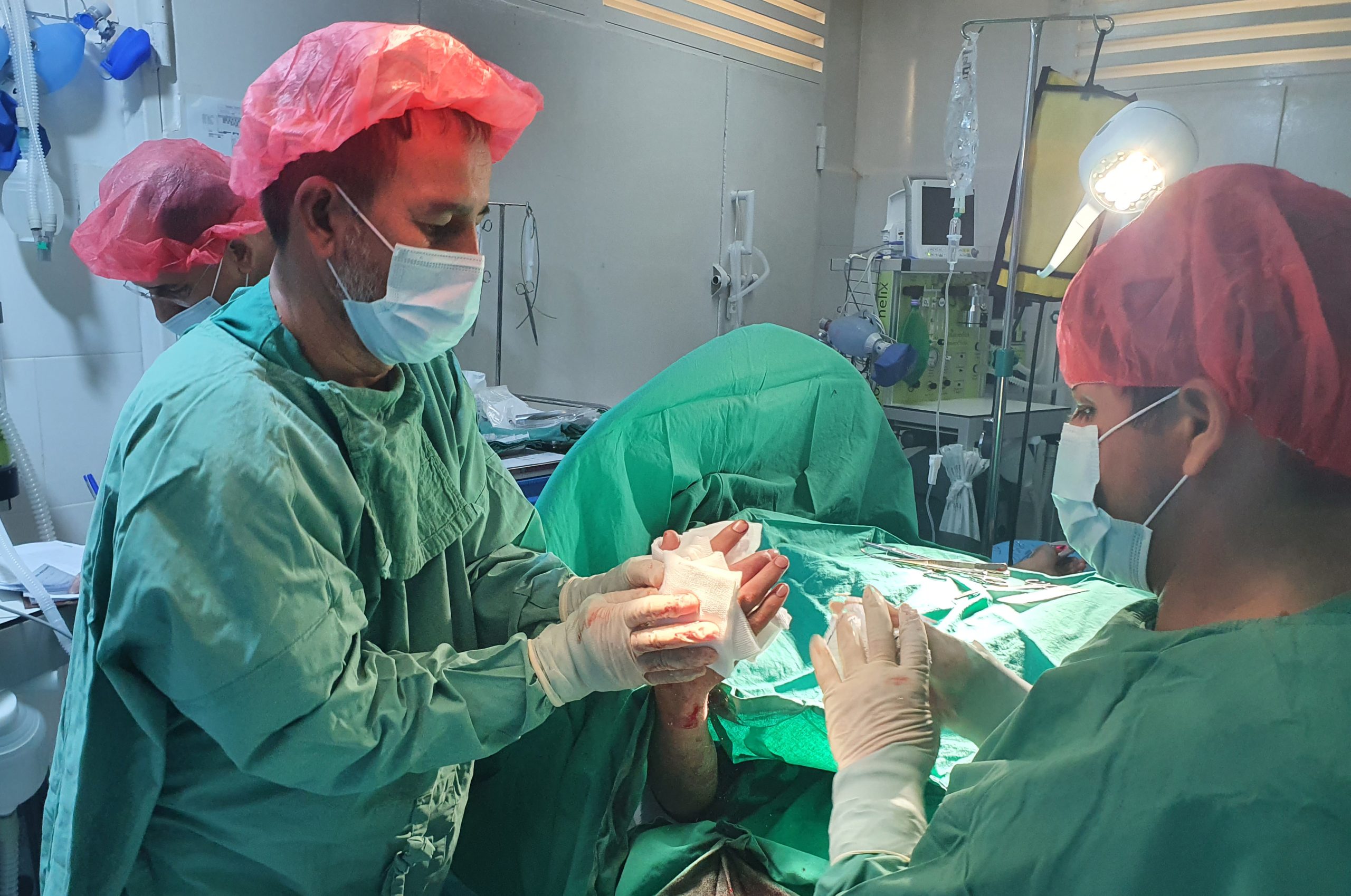 MSF surgical teams perform an operation on a patient injured by the fighting in Kunduz at the MSF Kunduz Emergency Trauma Unit. Afghanistan, August 2021. © MSF