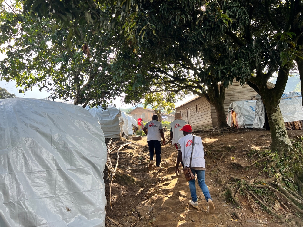 MSF staff walk up hill to mobile clinic