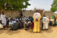 MSF teams are assessing the medical situation of newly arrived refugees in Adré seated in front of the fence.