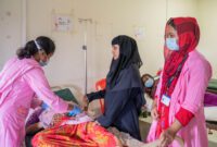 A Rohingya woman who is in early labour is being comforted by her female relative, while MSF’s midwife monitors the heartbeat of the foetus at MSF’s Goyalmara’s Hospital delivery room.