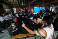 MSF community-based health promotion volunteers leading a session to a group of people inside a shade in Jamtoli Clinic, Ukhiya, Cox’s Bazar, Bangladesh.