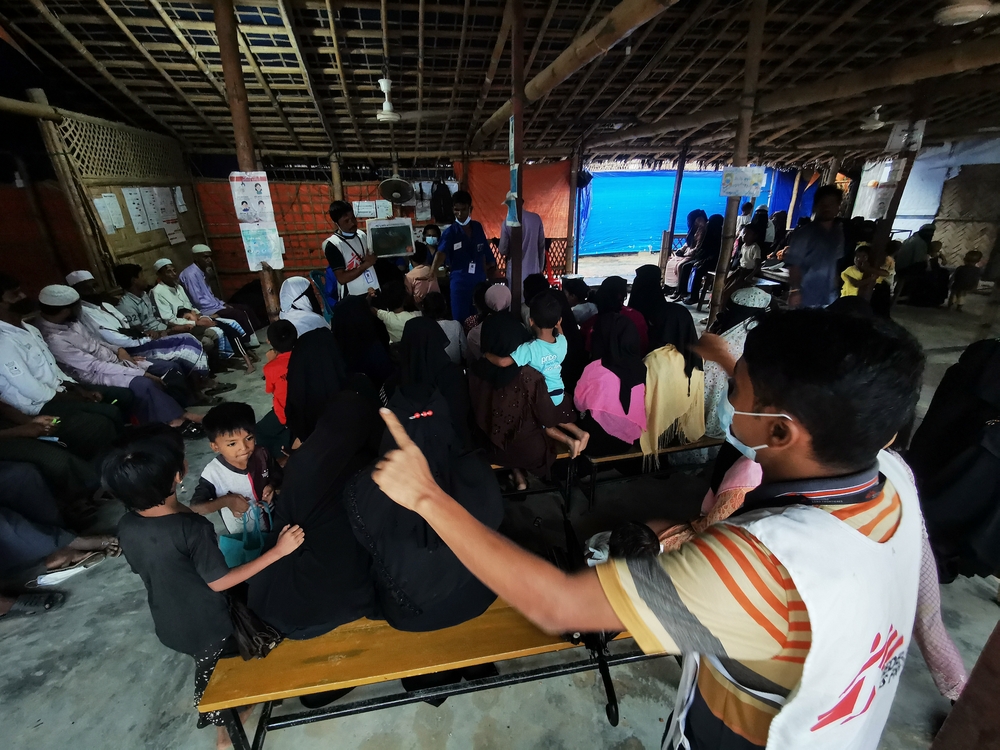 MSF community-based health promotion volunteers leading a session to a group of people inside a shade in Jamtoli Clinic, Ukhiya, Cox’s Bazar, Bangladesh.