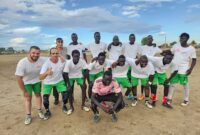 Football Team dressed in white shirts with MSF logo and green shorts comprising of MSF staff and community members during the multi-day football tournament in the Abyei Special Administrative Area, South Sudan.