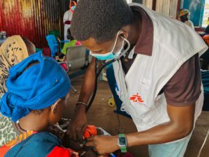 MSF doctor checking child's heart beat inside measles isolation unit at Um Sangour Refugees Camp, White Nile State.